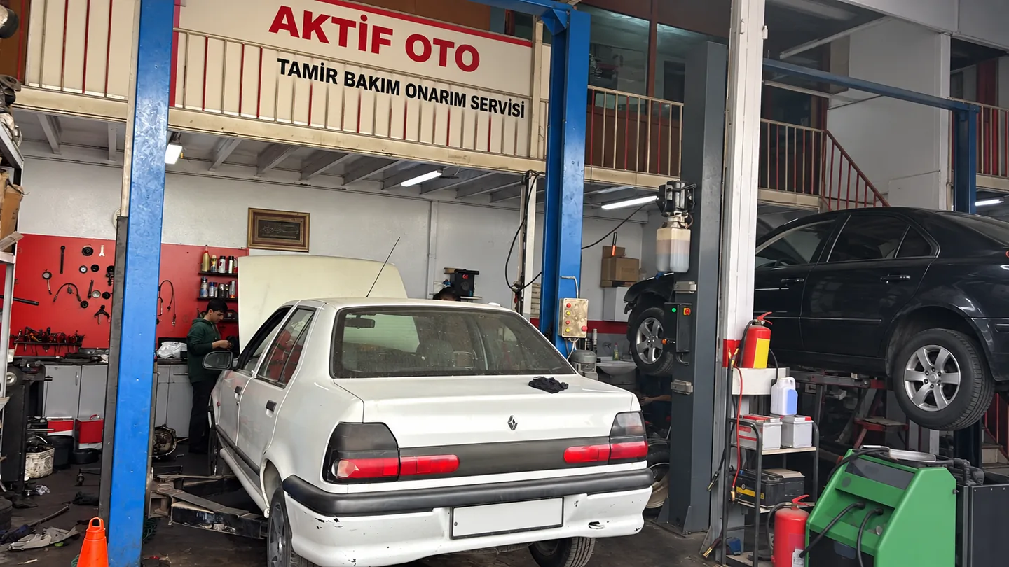 Atölyede liftteki beyaz araç ve bakım alanı
