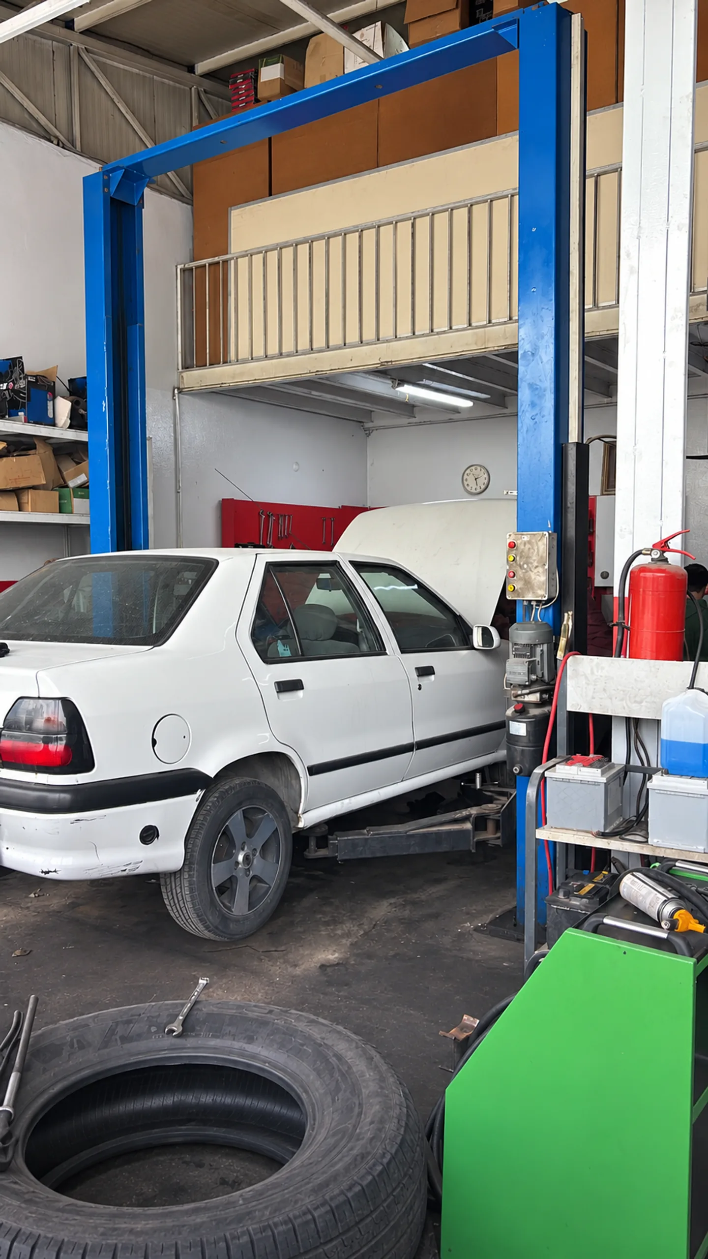 Aktif Oto servis alanında lift üzerindeki beyaz araç